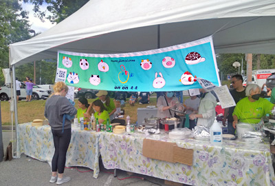 Jiaozi booth with banner - see volunteers hard at work